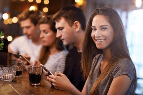 Friends drinking at a bar with mobile phones