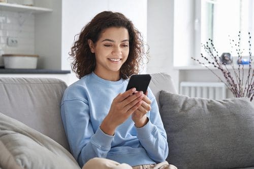 Woman looking at her mobile phone photo for social versus website post